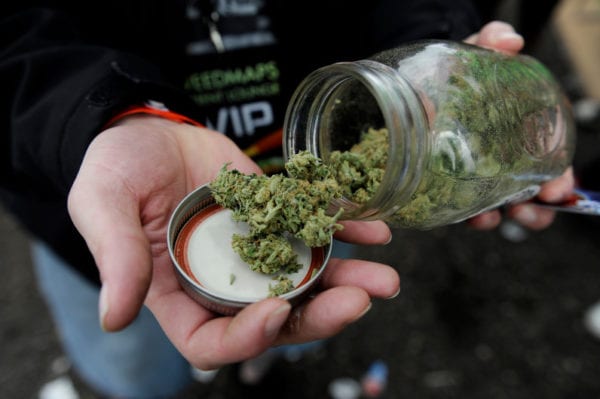 A marijuana aficionado displays a jar of weed he grew while wandering the concourse during the High Times US Cannabis Cup at the Exdo Center on April 20, 2013 in Denver.